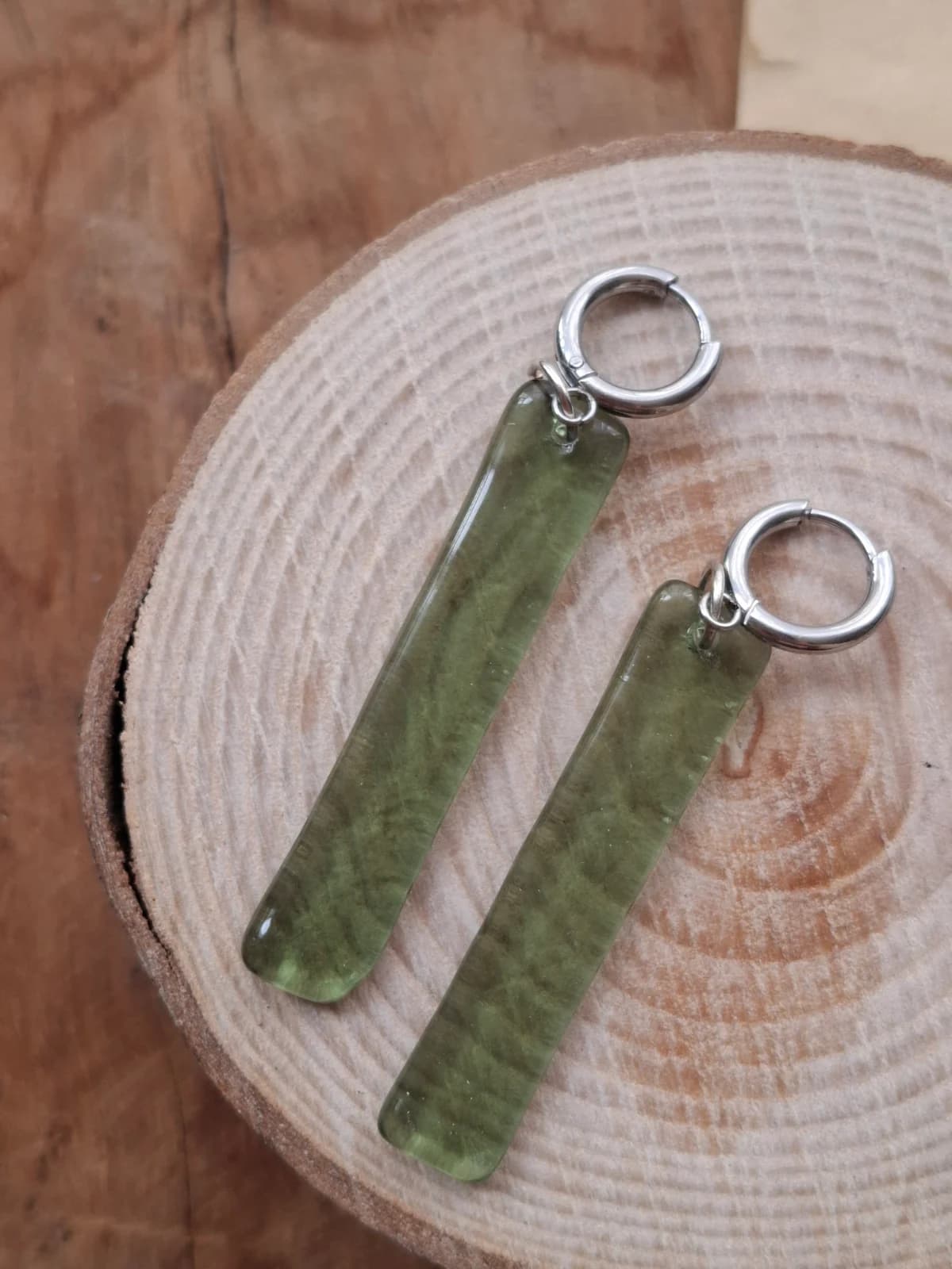 Boucles d'oreilles pendantes rectangulaires en verre vert sur une rondelle de bois
