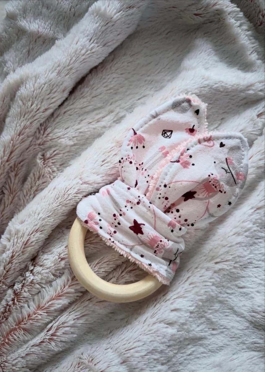 Anneau de dentition en bois avec tissu noué à motifs d'étoiles roses sur plaid moelleux