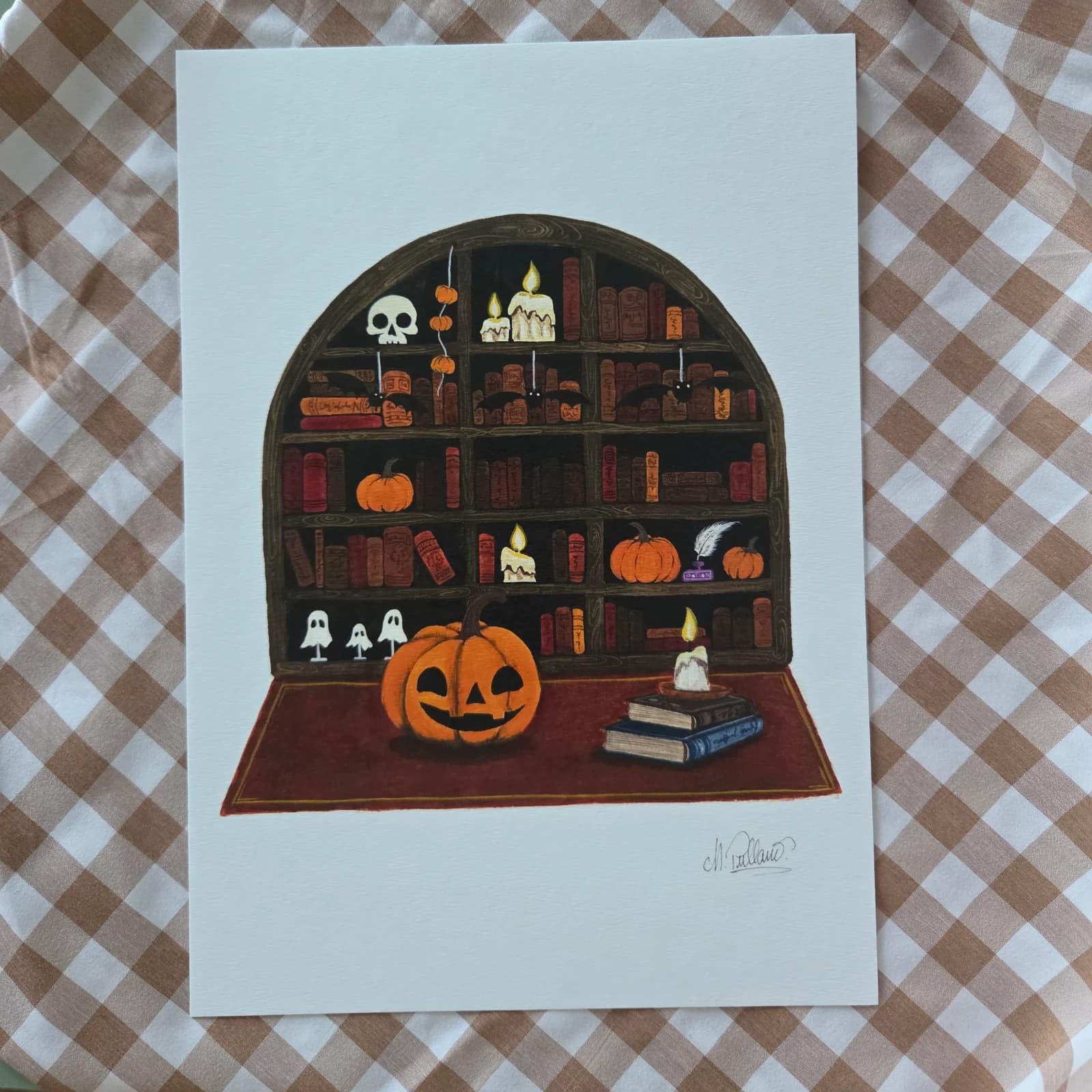 Illustration d'une bibliothèque en arche avec citrouilles et livres, posée sur un tissu à carreaux.