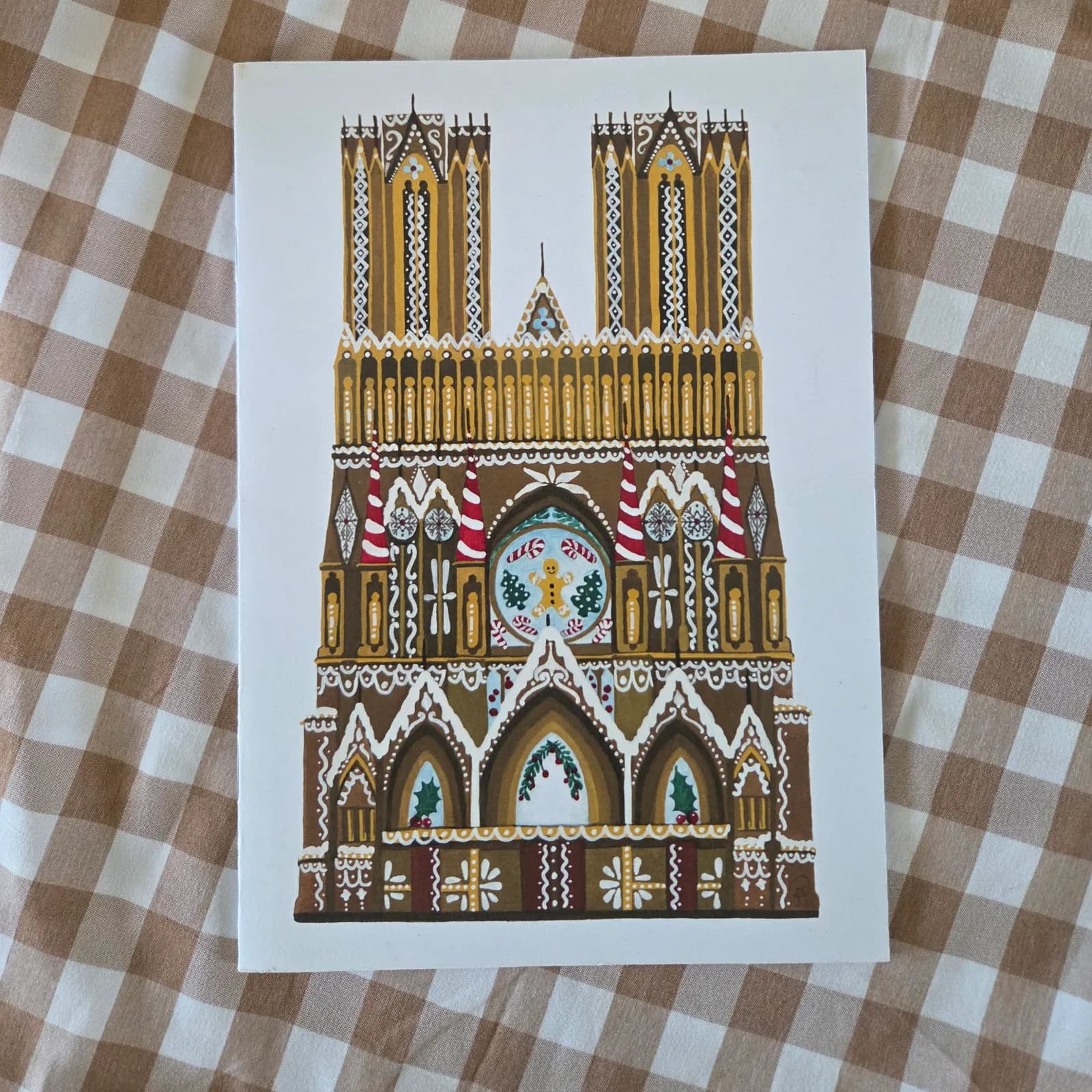 Couverture du carnet illustrant une cathédrale façon pain d'épices et sucre d'orge sur fond vichy.