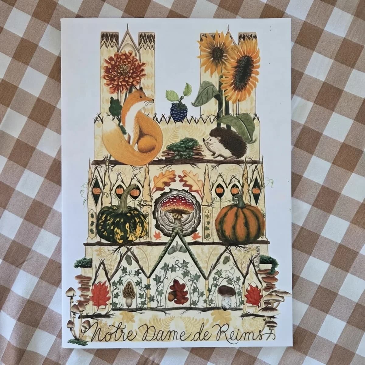Couverture de carnet illustrant Notre-Dame de Reims ornée d'un renard, d'un hérisson et d'éléments d'automne