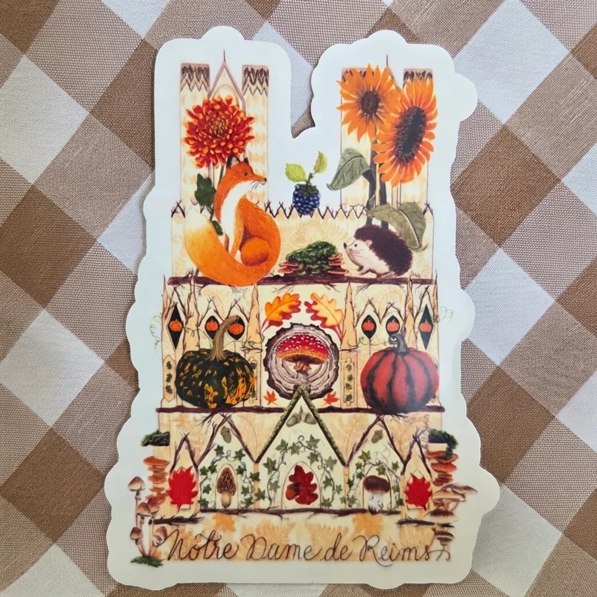 Sticker découpé représentant la cathédrale de Reims avec renard, citrouilles et motifs d'automne.